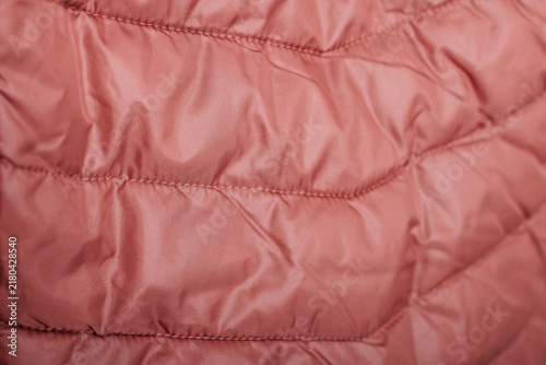 Pink quilted jacket fabric texture with stitched winter padding