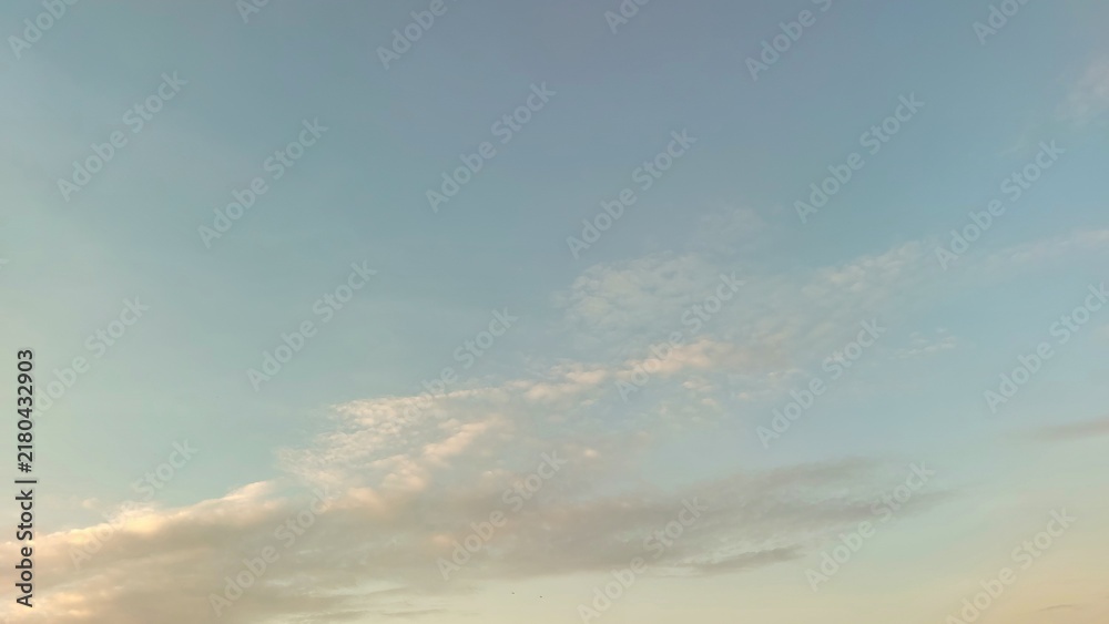 Obraz premium Soft pastel sky with wispy clouds and warm sunrise light
