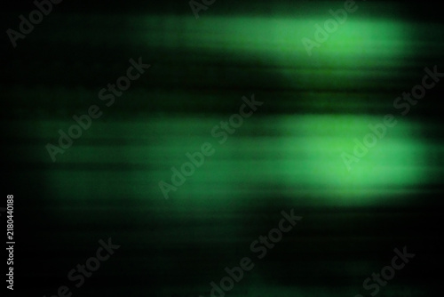 Fotografie Against a dark background, two flashes of greenish fluorescent light leave trail