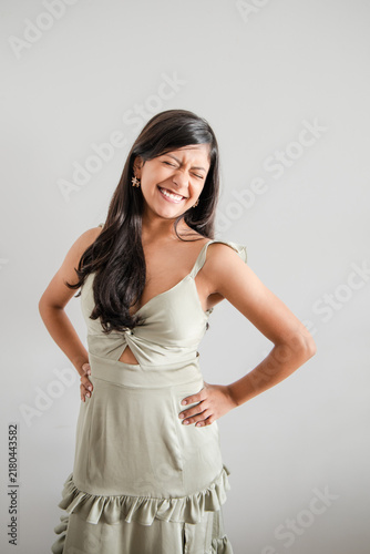 Woman in green dress laughing with eyes closed