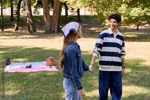 Fotografie A happy couple enjoys an outdoor picnic surrounded by colorful fall foliage