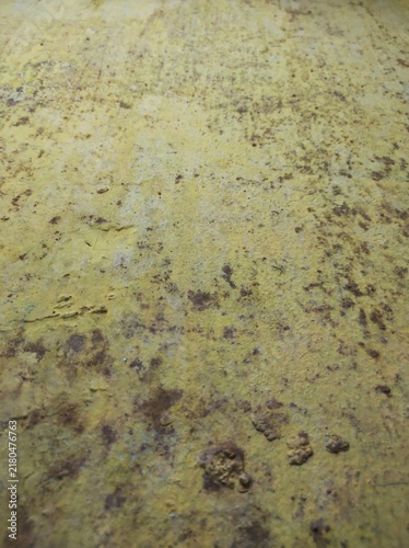 Weathered yellowish surface with scattered brown spots on the wall surface