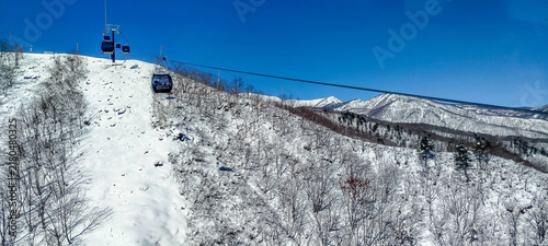 фотографія A breathtaking panoramic view of a snow-covered mountain and ski resort under a