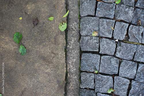 Cobblestone and concrete pavement dividing urban ground