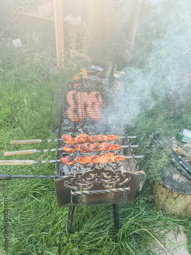 Shashlik Skewers and Sausages Grilling on a Metal Barbecue