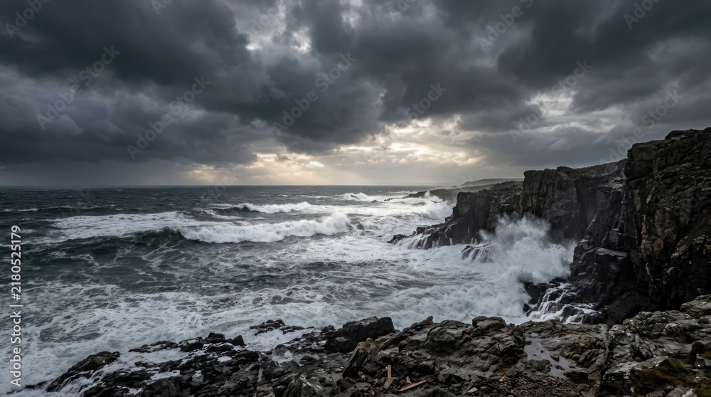 Fototapeta premium Clean Stormy Coastal Waves Crashing Against Rugged Dark Rocks Under Dramatic Cloudy Sky with high quality professional line art symbols for modern creative design and digital branding projects