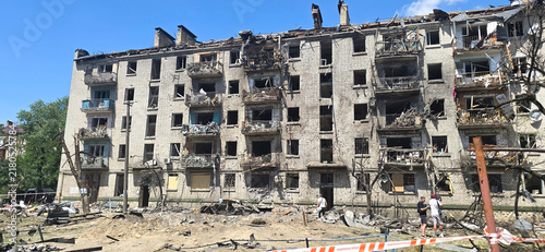 Cuadro en lienzo multi-story apartment block with severe facade damage and a wrecked car in the f