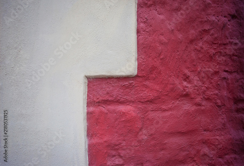 Plakat w ramie Tynk strukturalny koloru biało-czerwonego na ścianie budynku. White and red textured plaster on the wall of a building. 