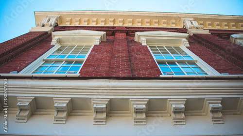 Ornate Historic Building Facade with Red-Framed Windows and Balconies, Romania
