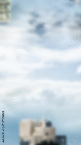 Animation of hanging house keys over inverted tall buildings against blue sky