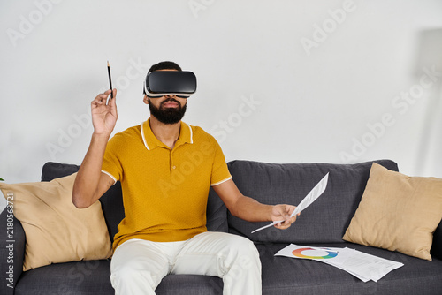 Obraz na plátne Engaging in virtual exploration at home with a stylish headset and creative tool