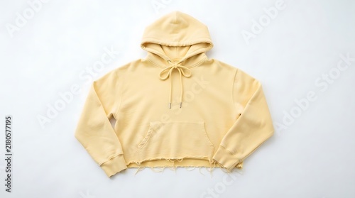 A trendy yellow cropped hoodie sweatshirt with a raw hem and hood strings for modern casual street style fashion