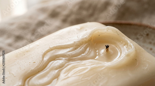 Close up of ivory wax surface with melted texture and candle wick