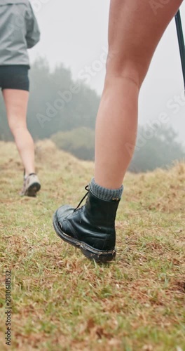 Person, legs or hiking with boots or walking stick on grass field for adventure, journey or trip. Active, closeup or hiker with shoes or aid for physical activity or trekking exercise in forest