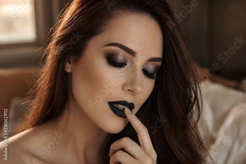 Plakat w ramie donna si tocca le labbra con il dito con make-up scuro