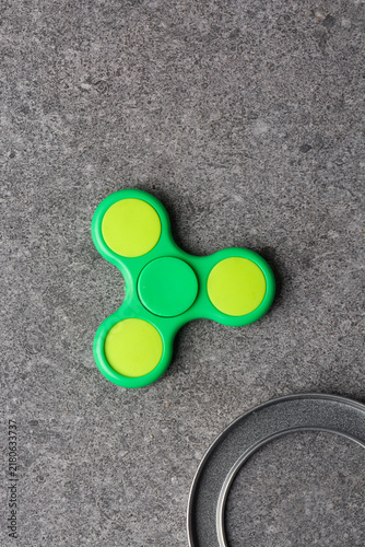Foto Overhead view of green fidget spinner on grey textured countertop, top view of g
