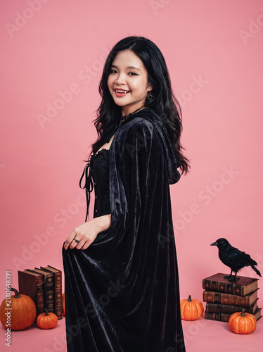 Foto Cloaked woman sitting with pumpkins