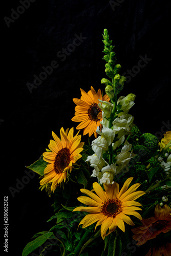 Sunflower bouquet with white snapdragon flowers on black background