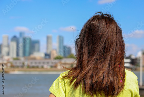 Quadro su tela Rear view of young woman looking at Canary Wharf skyline in London