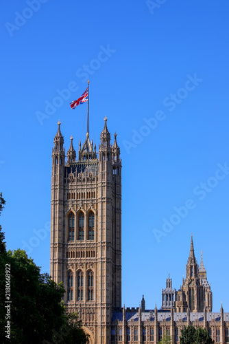 Photography Victoria Tower at Palace of Westminster with Union Jack flag flying against clea