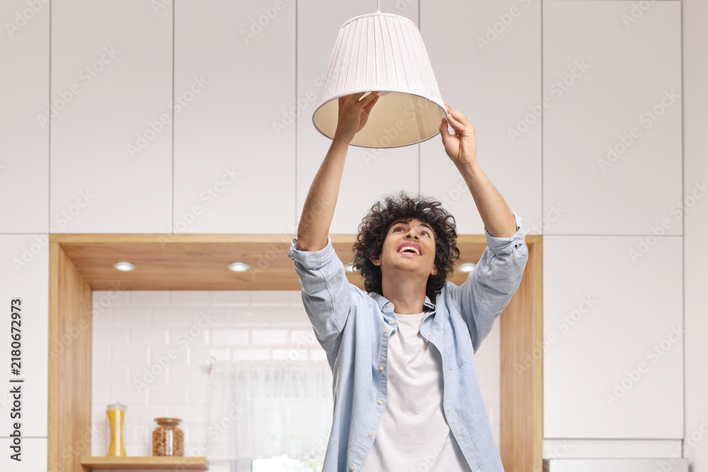Obraz premium Young man changing a light bulb