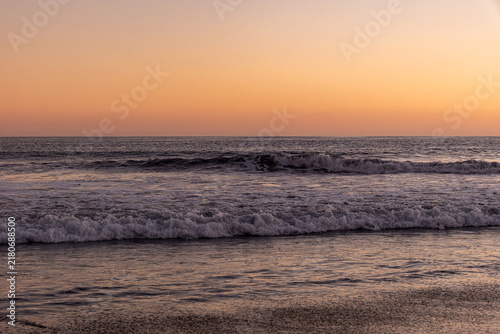 Quadro su tela Ocean waves washing ashore under a pastel dusk sky in Maspalomas