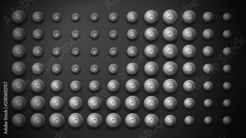 A monochromatic grid displaying spheres of varying sizes in ordered sequence