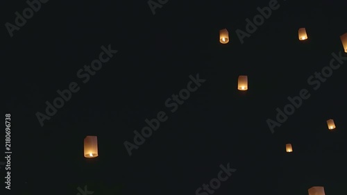 4K footage of many floating lanterns rising into the dark night sky. Yee Peng Festival celebration in Chiang Mai, Thailand. Traditional Thai Lanna culture and ceremony.