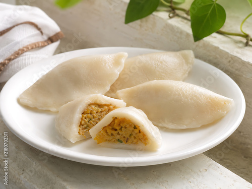 Traditional Bihari dal pitha, delicate rice-flour dumplings filled with seasoned lentils, one cut open for clear interior detail
