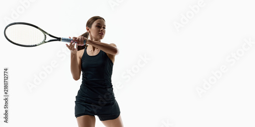 Focused female tennis player holding racket near shoulder on white background. Concept of athlete portrait, match readiness, mental focus, active lifestyle.