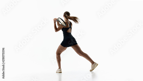 Foto Female tennis player driving dynamic backhand shot on white studio background
