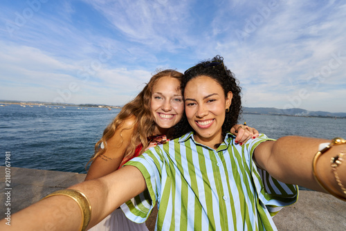Happy women friends taking selfie by the sea