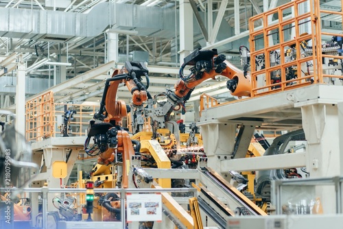 Foto Automated robotic arms working on vehicle assembly line in car factory with robo