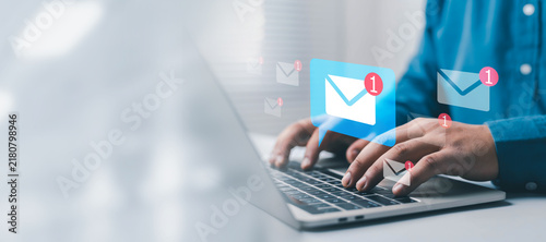 Email notification concept showing a professional using a laptop with digital mail icons and unread alerts, representing communication, inbox management, online messaging, business correspondence,