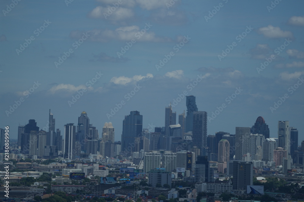 Fototapeta premium A panoramic cityscape of high rise towers packed with skyscrapers and office towers over the capital of Thailand in Southeast Asia, a clean modern wide angle composition.