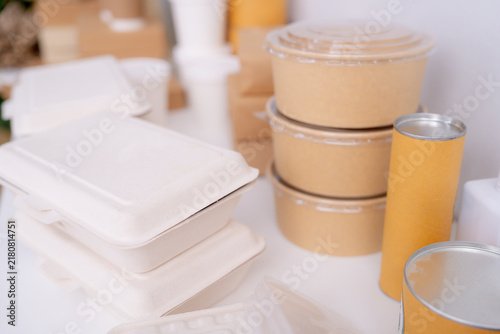 Fotografie A stacked bagasse clamshell leans on a kraft paper soup cup and tumbler, at an eco conscious design agency in Asia, young professionals planning a climate friendly architecture project