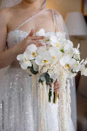 Bride holding luxury white orchid and amaranthus wedding bouquet