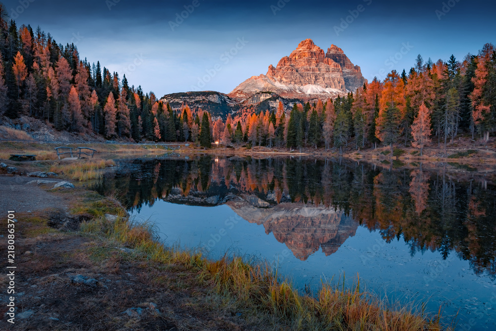 Obraz premium Majestic autumn scene of Antorno lake with Tre Cime Di Lavaredo peak on background. Wonderful evening scene of Dolomite Alps, blue hours picture, Italy, Europe. Beauty of nature concept background.