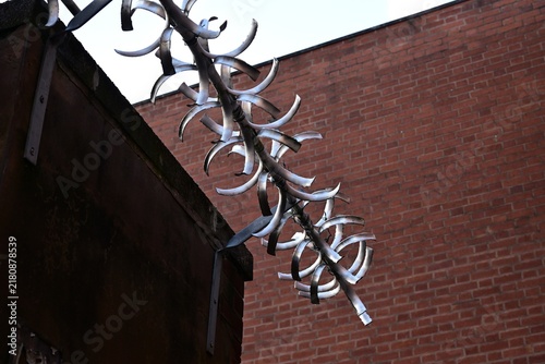 Obraz na płótnie Spiral metal security blades on wall against brick background
