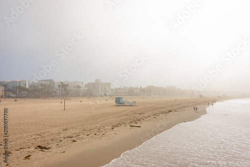 Canvas Print Blue wooden lifeguard tower on foggy Santa Monica State Beach in foreground with
