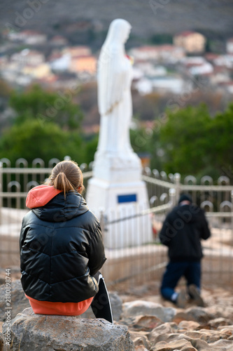 Canvastavla Tween girl praying at the statue of the Virgin Mary on Mount Podbrdo,  the Apparition Hill overlooking Medjugorje, Bosnia and Herzegovina
