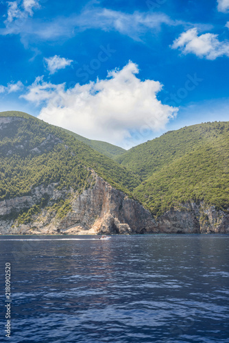 Breathtaking green limestone cliffs crystal clear blue sea rugged Greek coastline summer bay paradise view. Peaceful summer nature seascape landscape. Scenic Mediterranean travel tranquil wellbeing
