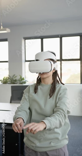 Vertical video: African nonbinary in white VR headset after demo reaching then pinching at office