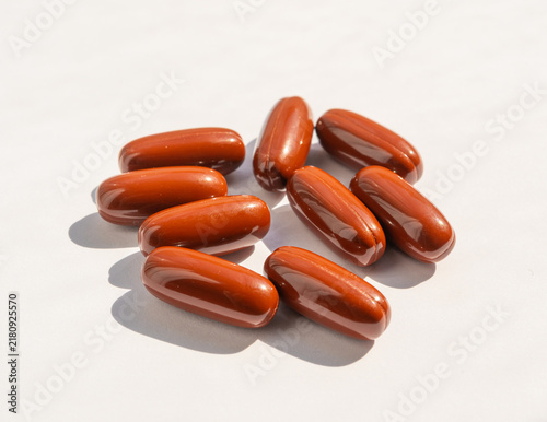 Brown gel pills, dark red capsules close up