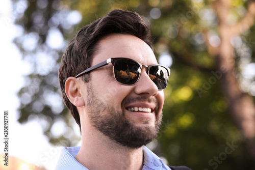 Handsome man wearing stylish sunglasses in park