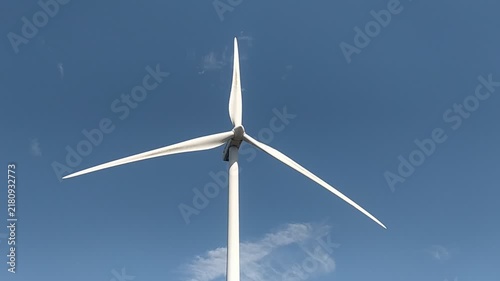 An elegant wind turbine rises into a clear blue sky, evoking a sense of hope and progress for clean energy. Perfect for environmental and sustainability concepts. Nobody.