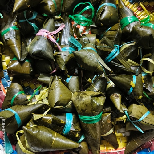 Fotografie The image shows a large batch of freshly wrapped zongzi (also known as bak chang or sticky rice dumplings) tied with colorful plastic string