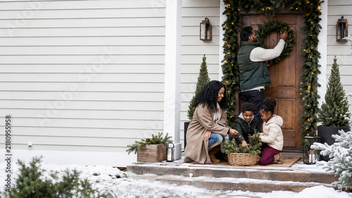 Family Decorating Front Porch for Christmas in Winter