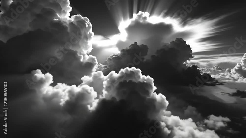 Dramatic cloudscape in monochrome with bright sun rays breaking through, creating an atmospheric cinematic scene