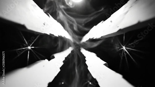 Abstract black and white perspective looking up with intersecting light beams and smoke for a minimalist or experimental visual